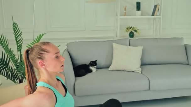 Chica deportiva realizando ejercicio físico utilizando una silla en casa — Vídeo de stock