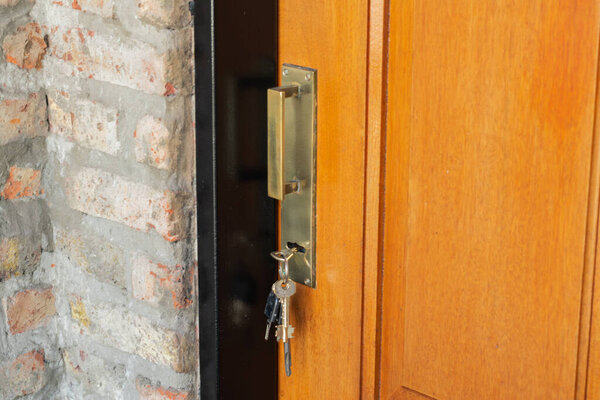 Ключи помещены в замок деревянной двери с бронзовой фурнитурой
