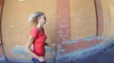 Bologna, Italy - September 29, 2018: SLOW MOTION side view of woman running under San Lucas portico: the longest porch in the world leading to the San Luca Sanctuary on Colle della Guardia.