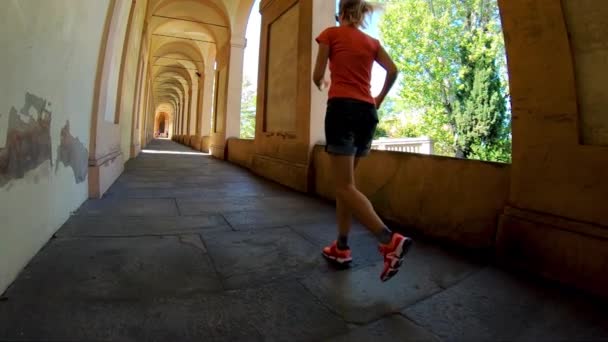 Moción Lenta Una Mujer Ropa Deportiva Que Corre Bajo Pórtico — Vídeos de Stock