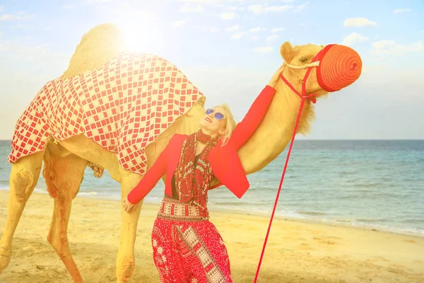 Femme avec chameau au coucher du soleil — Photo