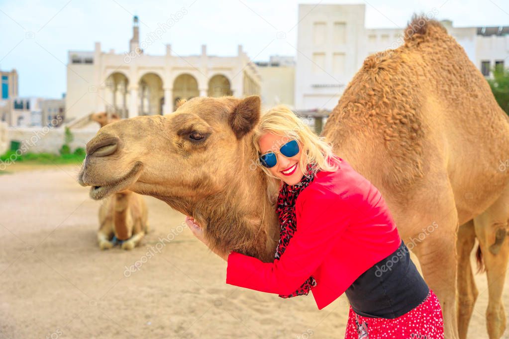 Woman embraces camel