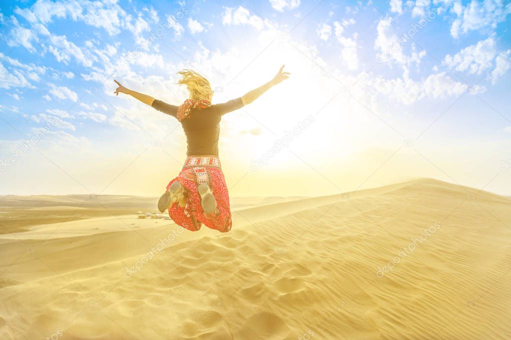 Woman jumping in Qatar desert