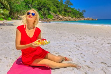 Woman eats tropical fruit