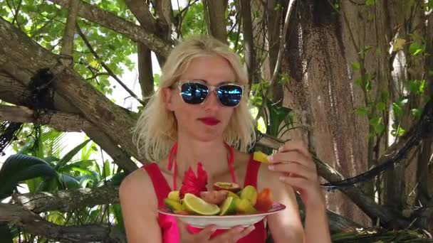 Mujer come frutas tropicales — Vídeo de stock