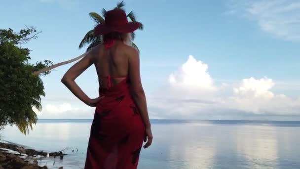 Femme blonde en sarong rouge sur un rivage — Video