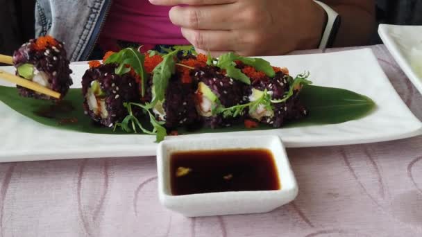 Vrouw uramaki van garnalen tempura — Stockvideo