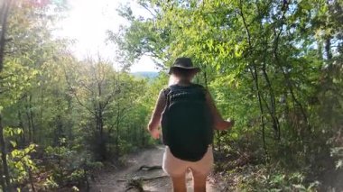 Sırt çantalı gezgin, Tuna vadisinde orman yolunda yürüyor ve Sırbistan ve Romanya 'daki Büyük Kazan bölgesinin güneşli doğası ve manzarasının tadını çıkarıyor. Yavaşlama Hareketi