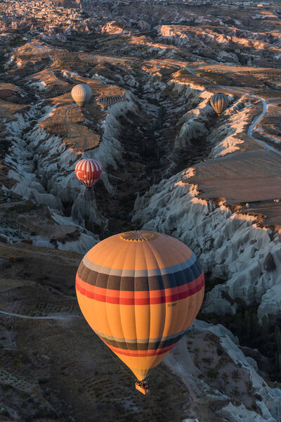 Beautiful hot air balloons flying over the hills and valleys in Cappadocia, Turkey