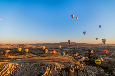 Tüm benzersiz jeolojik özellikleri Kapadokya'nın üzerinde gündoğumu sırasında Türkiye'de uçan çok sayıda sıcak hava balon havadan görünümü