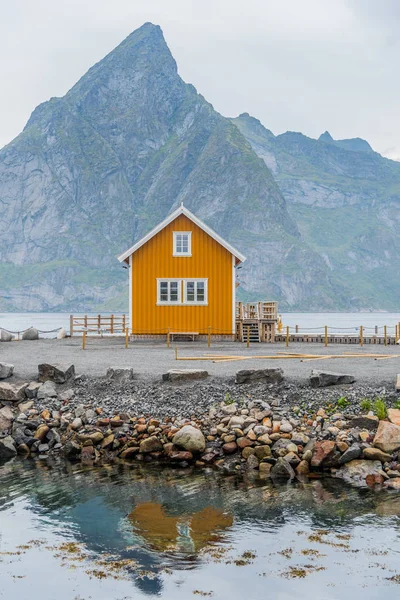 Sakrisy sarı bir balıkçı kulübesi, Nordland ilçesinde Lofoten adalarımoskenes Belediyesi küçük bir balıkçı köyü, Arka planda bir dağ ile Norveç