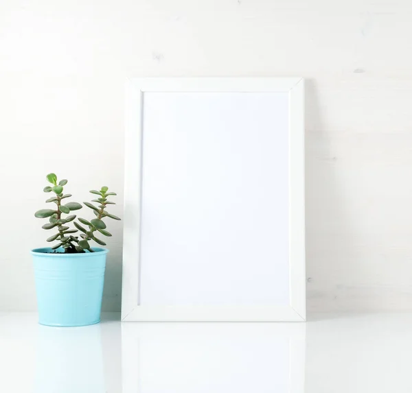 White frame, succulent on a white table against the white wall. Mockup with copy space in Scandinavian style