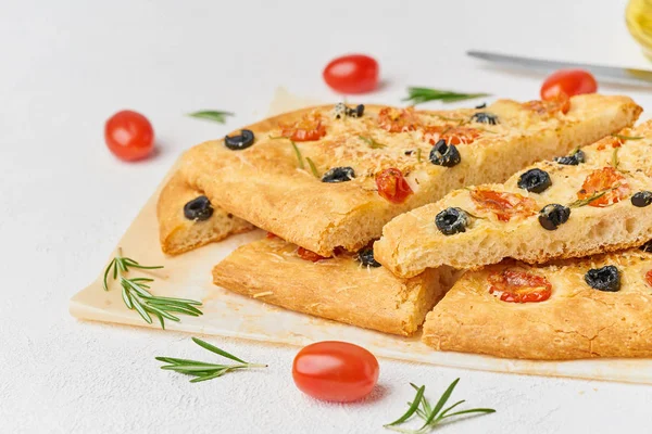 Focaccia, pizza, sliced italian flat bread with tomatoes, olives