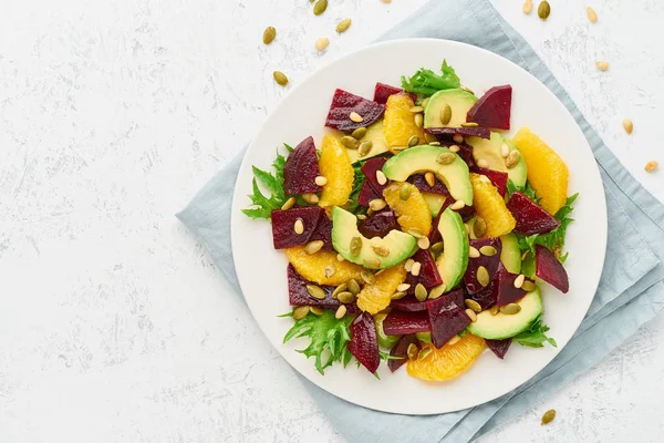 Vegan salad with beet curd avocado orange feta ricotta and pumpkin seeds, keto ketogenic dash diet, top view copy space, pastel modern background