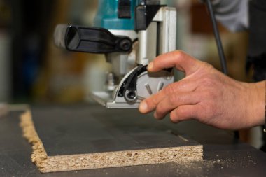 Closeup carpenter'ın elindeki testere makinesi kullanma