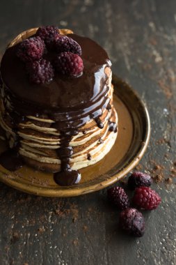 Bir yığın krep çikolata ve ahududu tepesi ile