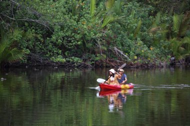 Erkekler ve kadınlar kanalda kayak yapıyor.