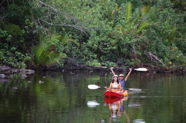 Erkekler ve kadınlar kanalda kayak yapıyor.
