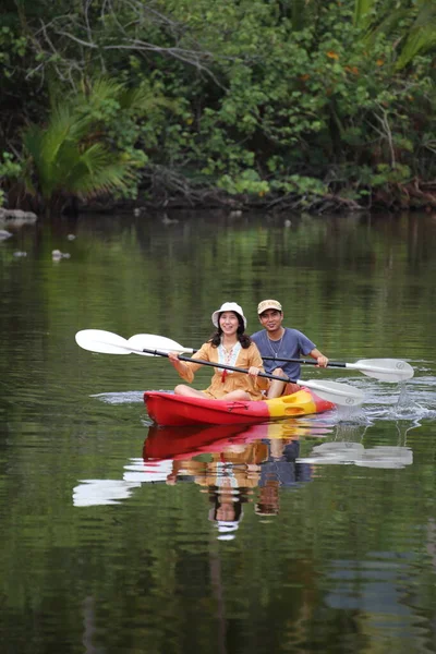 Erkekler ve kadınlar kanalda kayak yapıyor.