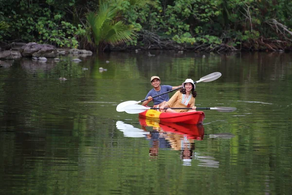 Erkekler ve kadınlar kanalda kayak yapıyor.