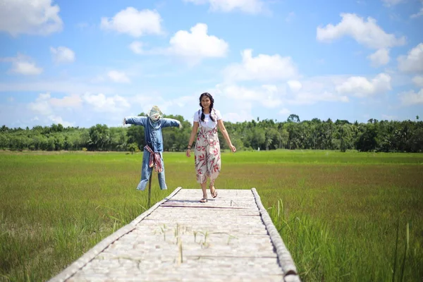 一个女人站在稻田里的一座木桥上 — 图库照片