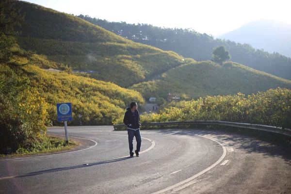 İnsanlar Doi Mae U Kho, Mae Hong Son, Tayland 'da sarı çiçekler (Tung Bua Tong) ve Meksika ayçiçekleri ile dolu dağ manzaralarında gezinirler.