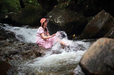 Phlio şelalesinde oynayan bir kadın, Chanthaburi, Tayland