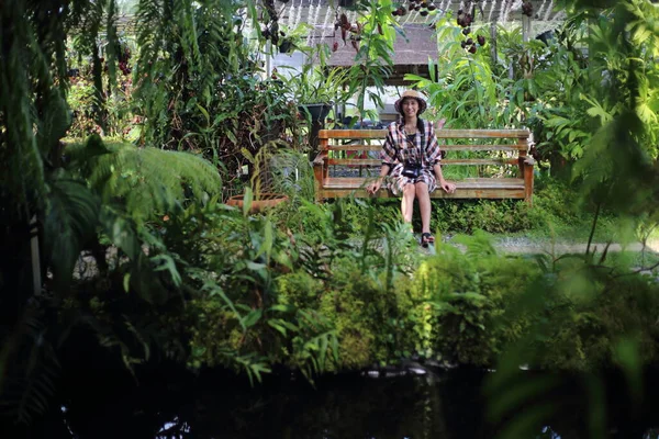 一个女人坐在一个绿色的花园里 — 图库照片