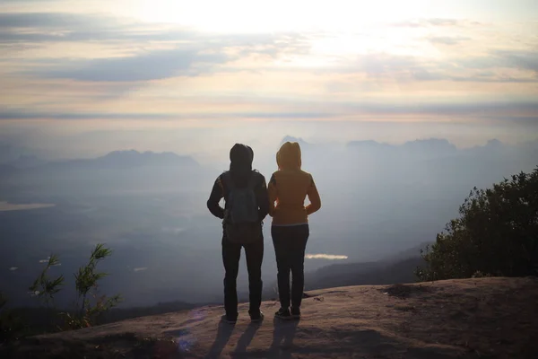 Erkekler ve kadınlar uçurumun kenarında, Phu Kradueng Ulusal Parkı, Loei, Tayland 'da güneşin doğuşunu bekliyorlar.