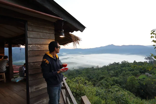 コーヒーカップを持っている男とタイのパヤオで朝にフランカの景色 — ストック写真