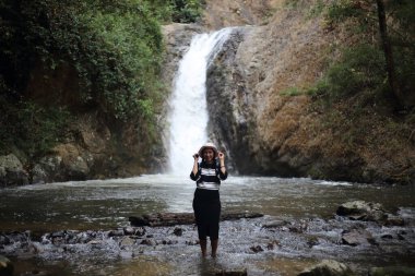 Chae Son Şelalesi 'nde duran bir kadın. Tayland' da Lampang 'da bir milli park.