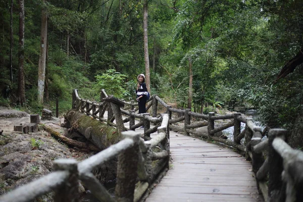 泰国兰榜茶森国家公园茶森瀑布桥上站着一位妇女 — 图库照片