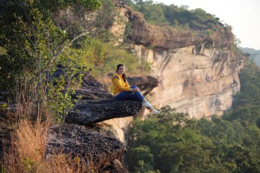 Pha Tam Ulusal Parkı 'nda uçurumda oturan kadın, Ubon Ratchathani, Tayland.