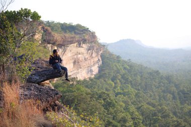 Pha Tam Ulusal Parkı 'ndaki uçurumda oturan adam Ubon Ratchathani, Tayland