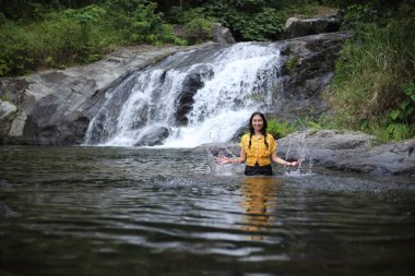 Klong Lan Ulusal Parkı 'ndaki Khlong Nam Lai şelalesinde oturan kadın, Kamphaeng Phet, Tayland