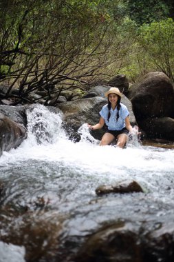 Chanthaburi, Tayland 'daki Trok Nong şelalesinde sırılsıklam olmuş bir kadın.