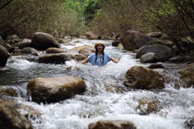 Chanthaburi, Tayland 'daki Trok Nong şelalesinde sırılsıklam olmuş bir kadın.