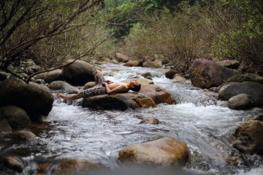 Chanthaburi, Tayland 'daki Trok Nong Şelalesinde uyuyan bir adam.