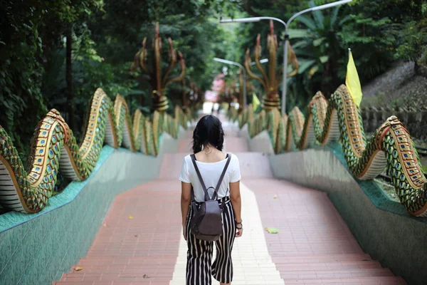 A woman walking the stairs of Khao Sukim temple in Chanthaburi, Thailand