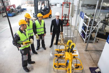 Yöneticisi ve işçiler fabrikada sac kaldırma aygıt yakınındaki