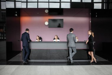 Resepsiyondaki ya da ofis binasındaki, oteldeki ya da havaalanındaki iş adamları