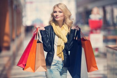 Satış ve süpermarket arka plan üzerinde renkli alışveriş torbaları ile gülümseyen insanlar-