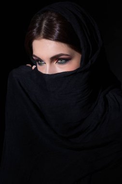 Koyu arka plan üzerinde niqab geleneksel peçe karşı güzel Müslüman kadın