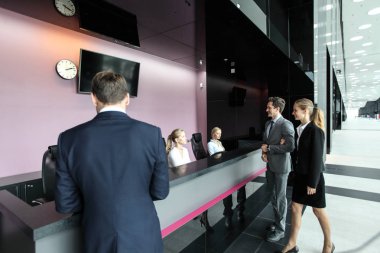 Resepsiyondaki ya da ofis binasındaki, oteldeki ya da havaalanındaki iş adamları