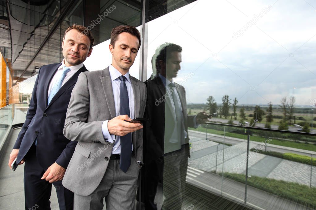 One business man spy on others businessman phone looking over the shoulder