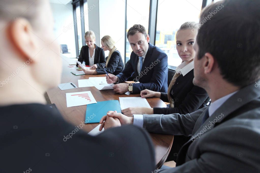 Business team working with documents together at meeting table in office