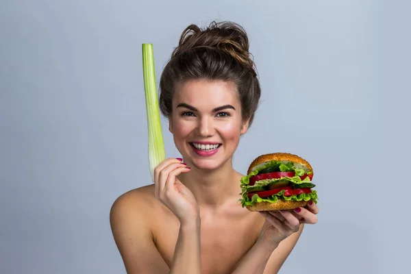 野菜と健康的な食事の概念 セロリの茎で作られたハンバーガーを保持している若い女性 — ストック写真