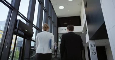 Modern iş adamları cam ofis binası salonunda yürüyüş