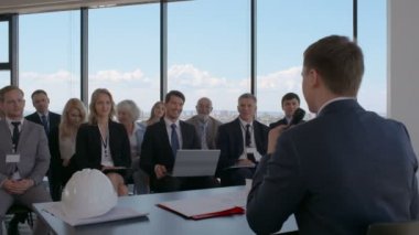 İş adamları ve sunum odası, konferans salonu, belgeler, inşaat kask ile hoparlör tablo görünümünden oturan yatırımcılar applauding seyirci