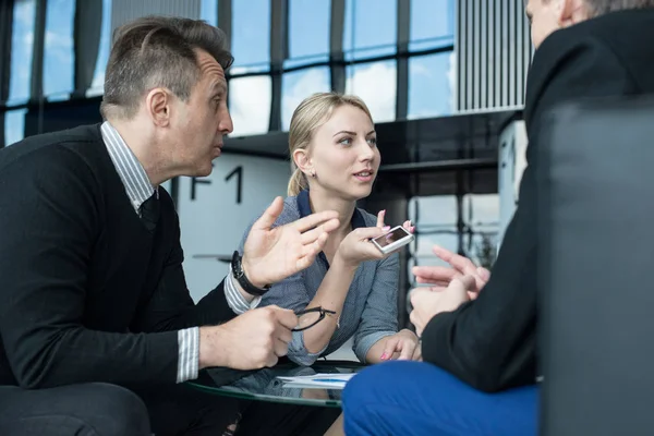 Portrait of happy business people talking at break in cafe sitting together at the table